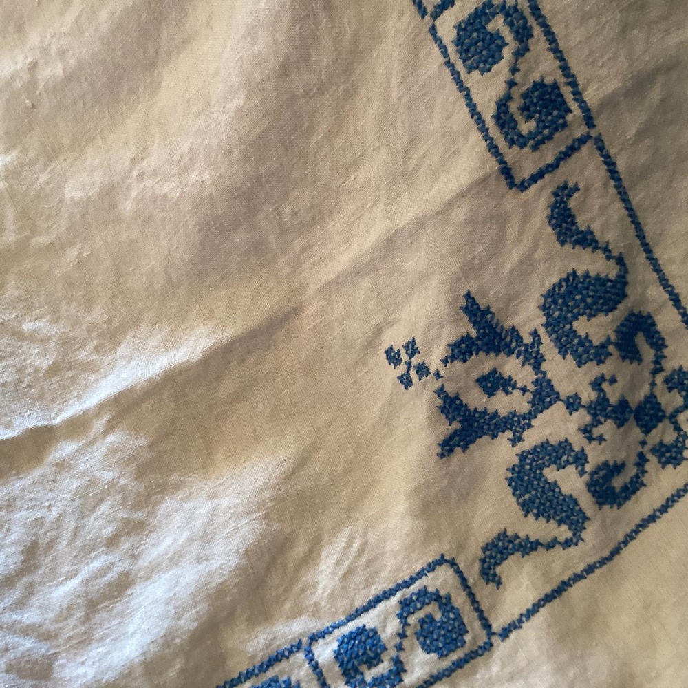 Cross stitched table cloth..  beige with blue stitch..52” x 72”